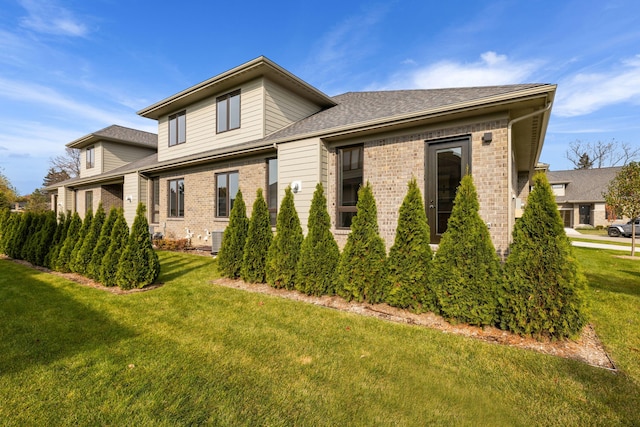 view of side of home with central AC and a lawn