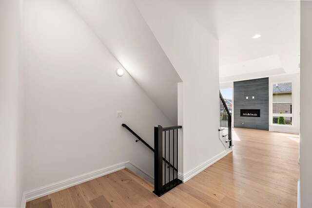 staircase with wood-type flooring and a fireplace