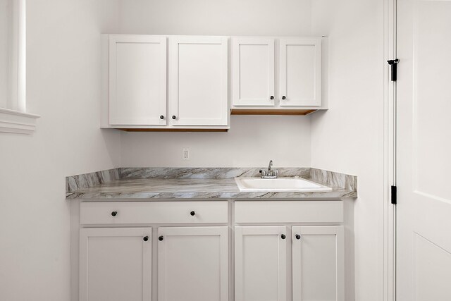 kitchen featuring white cabinetry and sink