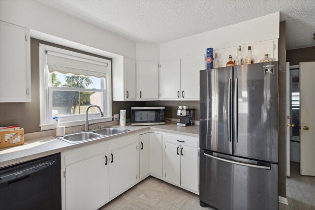 kitchen featuring white cabinets, a textured ceiling, appliances with stainless steel finishes, and sink