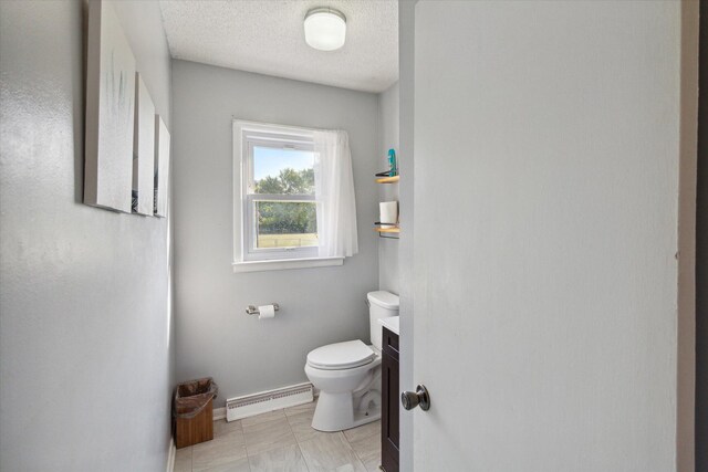 bathroom featuring vanity, a baseboard heating unit, a textured ceiling, and toilet