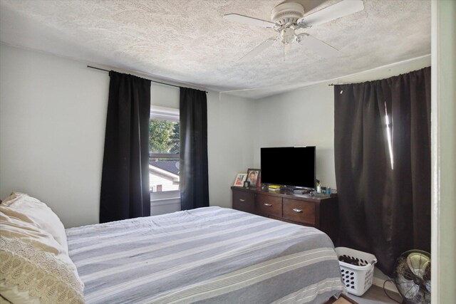 bedroom with a textured ceiling and ceiling fan