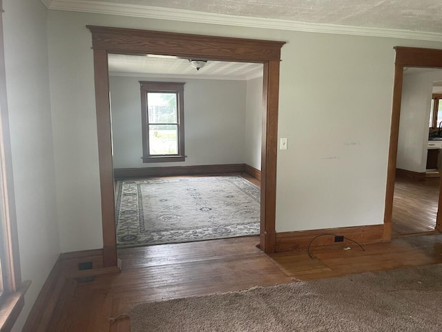 hallway featuring crown molding, dark wood-type flooring, and a textured ceiling