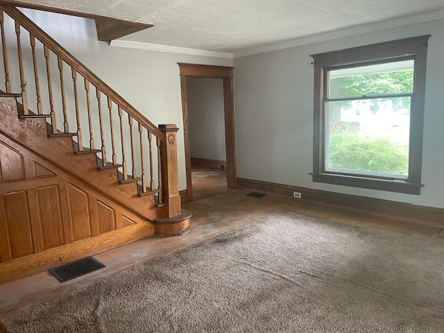 foyer featuring hardwood / wood-style flooring, crown molding, and a textured ceiling