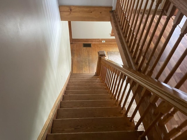 stairs featuring wood-type flooring