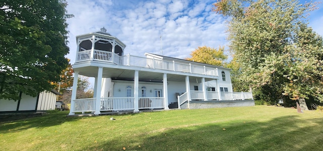 rear view of house featuring a lawn