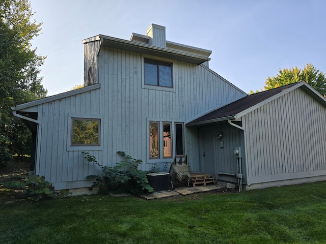 back of house featuring central AC and a lawn