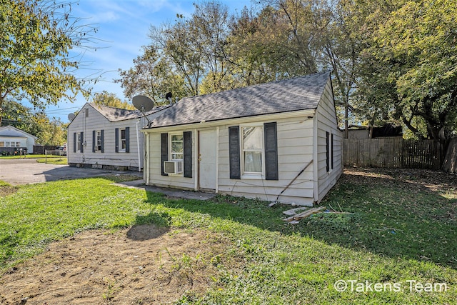 bungalow-style home featuring a front yard and cooling unit