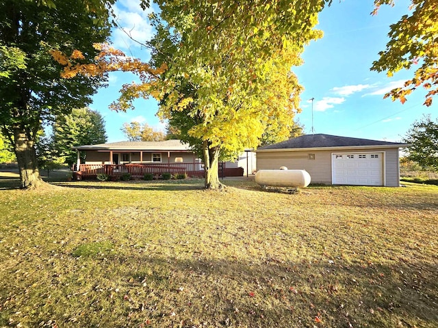 view of front of property featuring a wooden deck, a front yard, a garage, and an outdoor structure