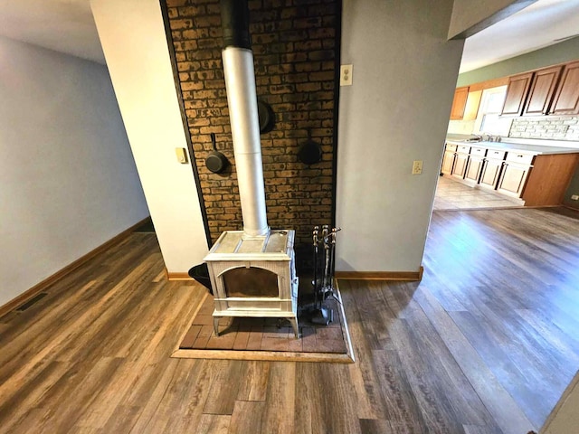 details with a wood stove, hardwood / wood-style floors, and tasteful backsplash