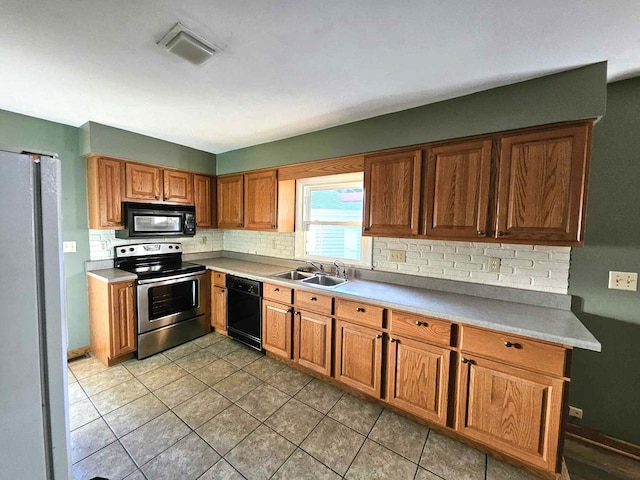 kitchen with decorative backsplash, black appliances, sink, and light tile patterned floors