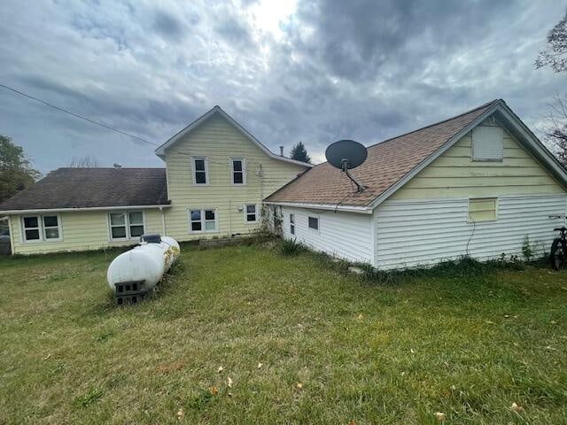 rear view of property featuring a lawn