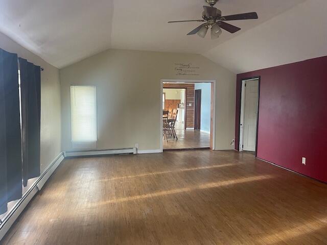 spare room featuring ceiling fan, wood-type flooring, and lofted ceiling