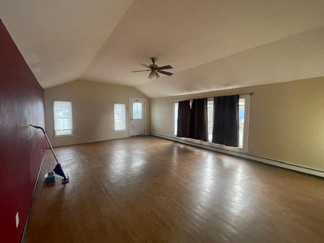 unfurnished room featuring wood-type flooring, plenty of natural light, ceiling fan, and lofted ceiling