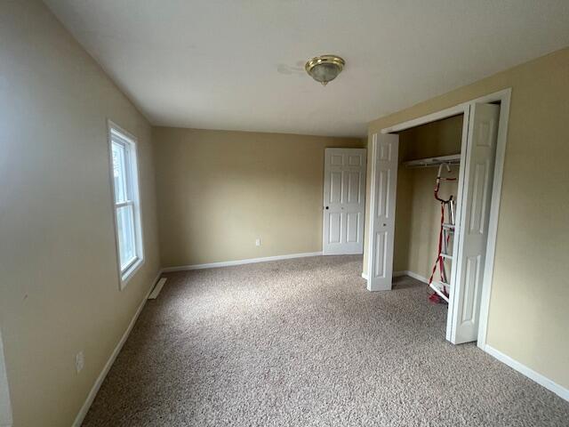 unfurnished bedroom with carpet flooring and a closet