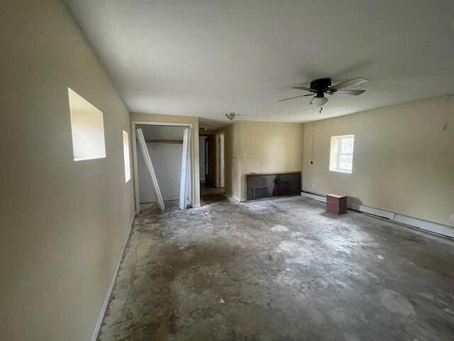 unfurnished living room featuring ceiling fan, concrete flooring, and a baseboard heating unit