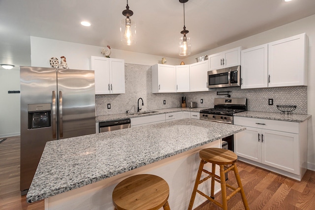 kitchen with stainless steel appliances, white cabinets, tasteful backsplash, and sink