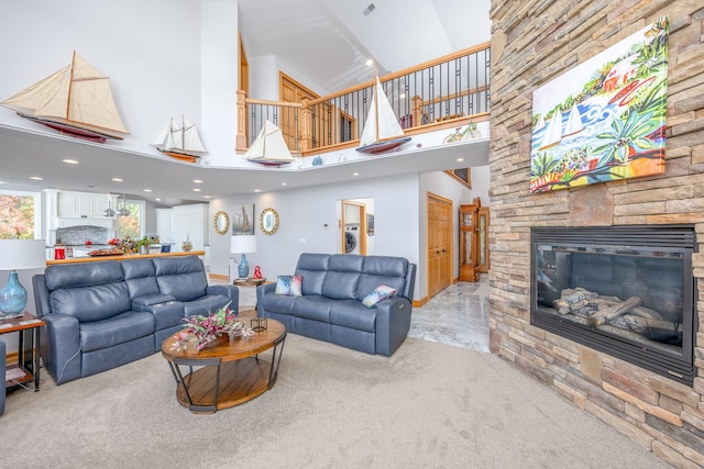 carpeted living room with a fireplace and a towering ceiling