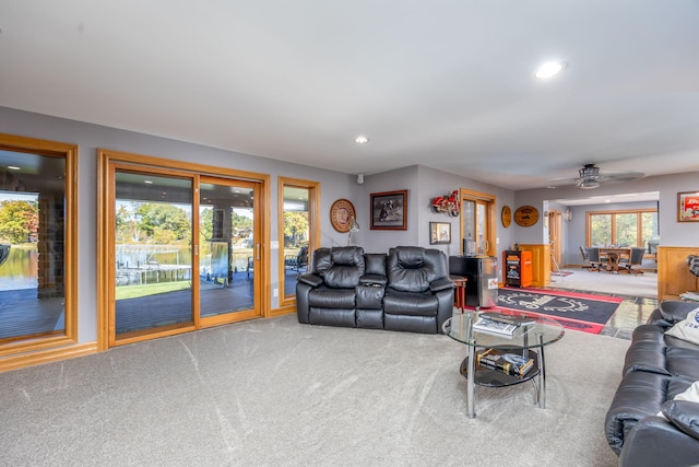 carpeted living room with ceiling fan