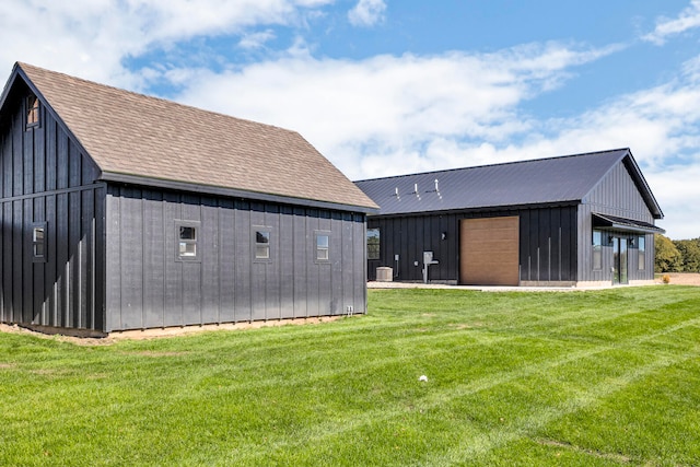 rear view of house with a lawn and an outdoor structure