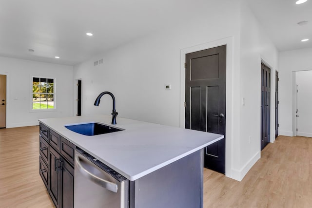 kitchen with an island with sink, light wood-type flooring, sink, and dishwasher