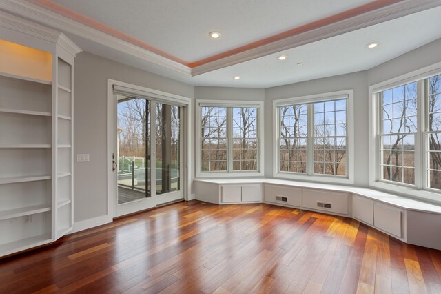 unfurnished sunroom with built in desk and a healthy amount of sunlight