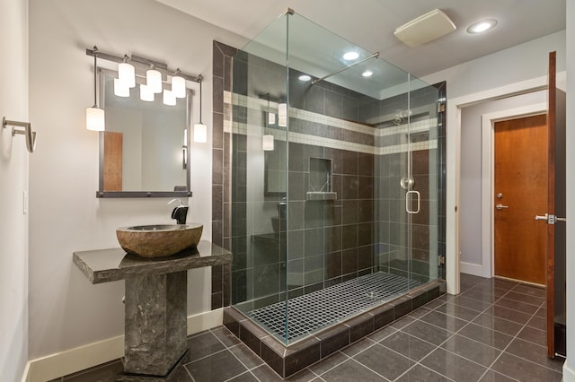 bathroom featuring tile patterned flooring, a shower with door, and sink