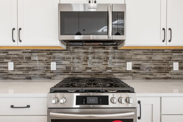 kitchen featuring white cabinetry, stainless steel appliances, and backsplash