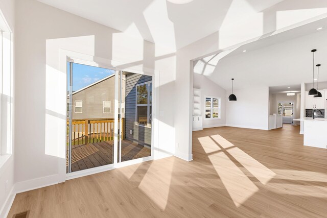 interior space with high vaulted ceiling and light hardwood / wood-style flooring