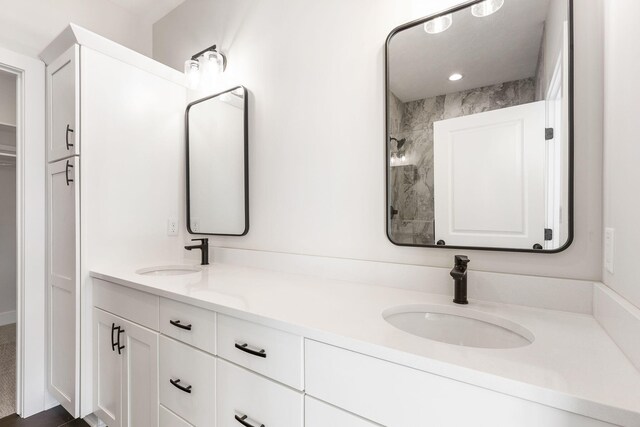 bathroom with vanity and a tile shower