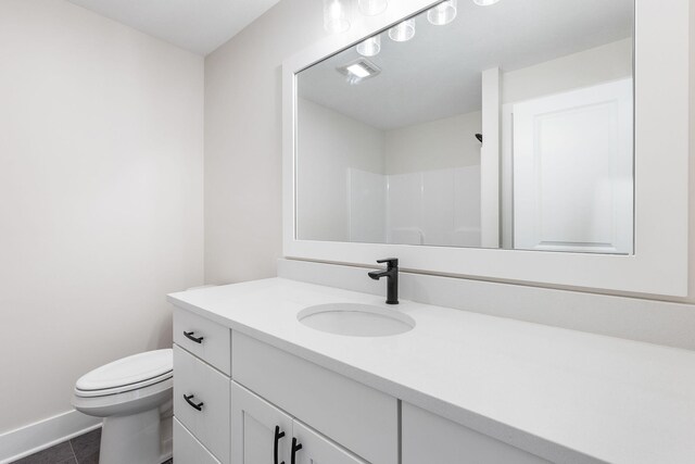 bathroom featuring vanity, tile patterned floors, toilet, and walk in shower