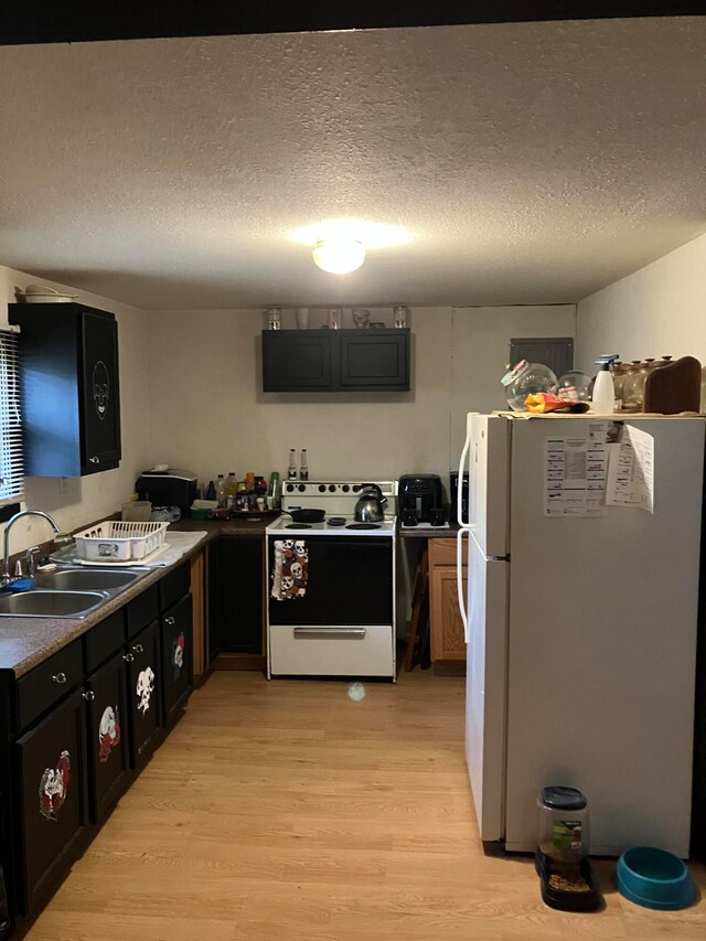 kitchen featuring white appliances, a textured ceiling, sink, and light hardwood / wood-style flooring