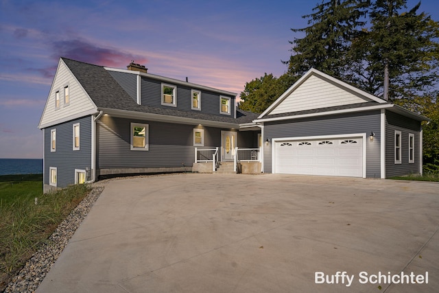 3163 N Scenic Dr, Muskegon, MI 49445 - view of front facade with a chimney, a garage, a shingled roof, concrete driveway, and a porch