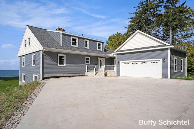 3163 N Scenic Dr, Muskegon, MI 49445 - view of front facade featuring a porch, an attached garage, concrete driveway, a chimney, and a shingled roof