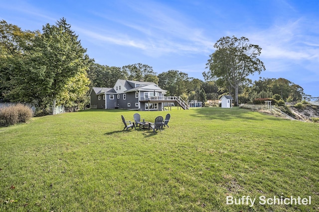 3163 N Scenic Dr, Muskegon, MI 49445 - view of yard with a storage shed, a fire pit, a deck, an outbuilding, and stairs