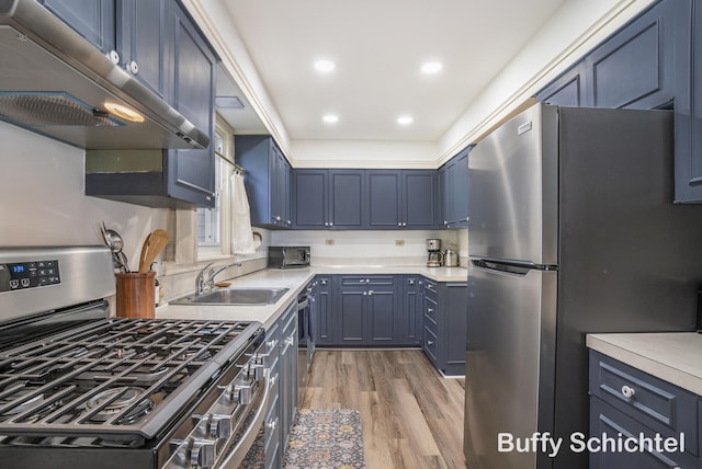 3163 N Scenic Dr, Muskegon, MI 49445 - kitchen with under cabinet range hood, a sink, light wood-style floors, light countertops, and appliances with stainless steel finishes