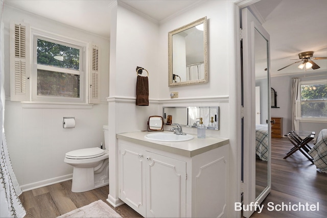 3163 N Scenic Dr, Muskegon, MI 49445 - full bath featuring toilet, ornamental molding, ceiling fan, vanity, and wood finished floors