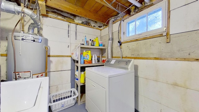 clothes washing area featuring water heater and washer / clothes dryer