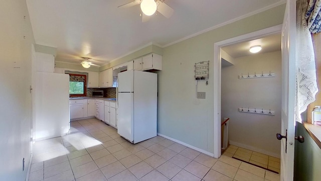 kitchen featuring crown molding, white cabinets, light tile patterned flooring, and white refrigerator