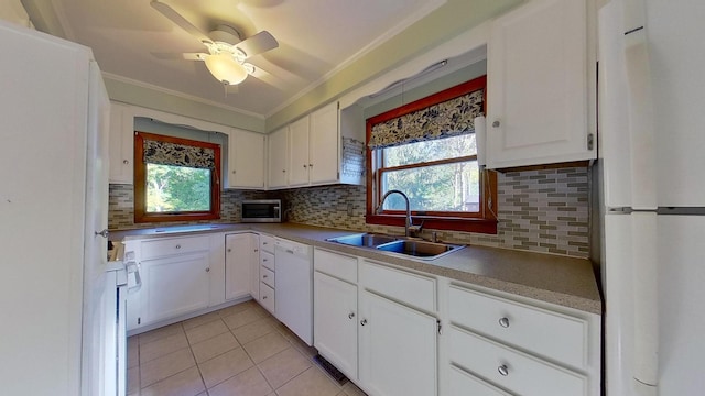 kitchen featuring white appliances, sink, a wealth of natural light, and white cabinets