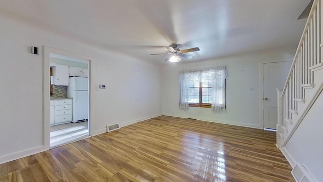 empty room with light hardwood / wood-style flooring and ceiling fan