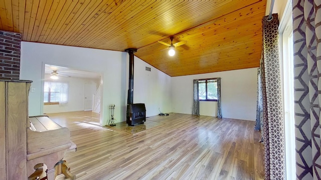 unfurnished living room with wood ceiling, a wood stove, ceiling fan, high vaulted ceiling, and light hardwood / wood-style flooring