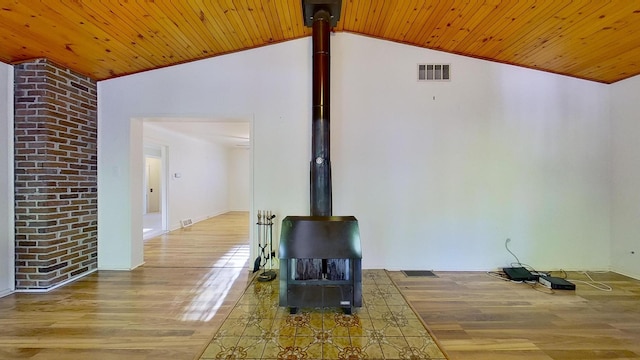 unfurnished living room with wood ceiling, a wood stove, vaulted ceiling, and hardwood / wood-style floors