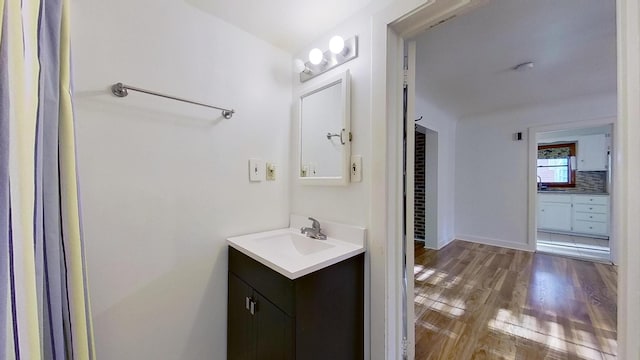 bathroom featuring vanity, tasteful backsplash, and wood-type flooring