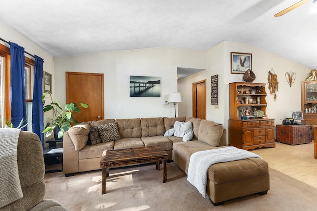 carpeted living room with vaulted ceiling and ceiling fan