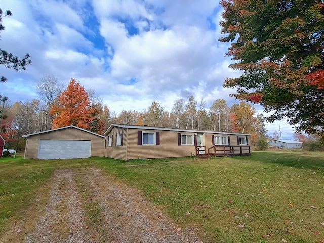 manufactured / mobile home with a garage, a front yard, an outbuilding, and a wooden deck