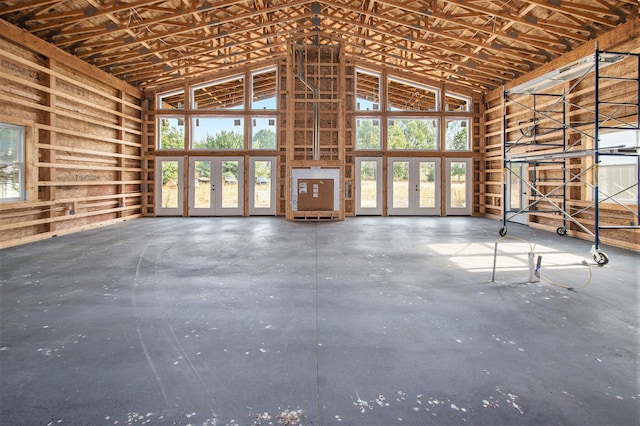 miscellaneous room featuring concrete flooring and a high ceiling