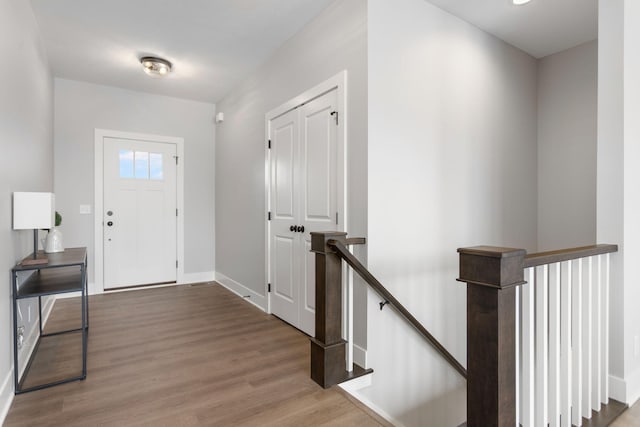 foyer entrance featuring baseboards and wood finished floors