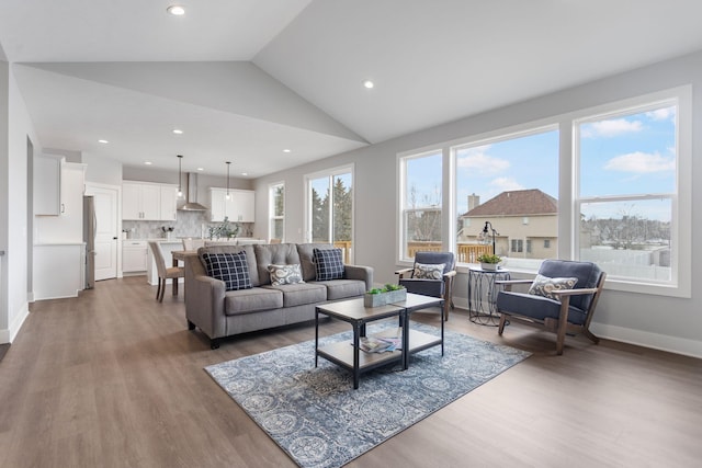 living room with lofted ceiling, recessed lighting, baseboards, and wood finished floors