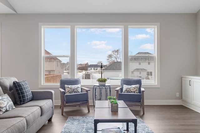 living area with baseboards and wood finished floors